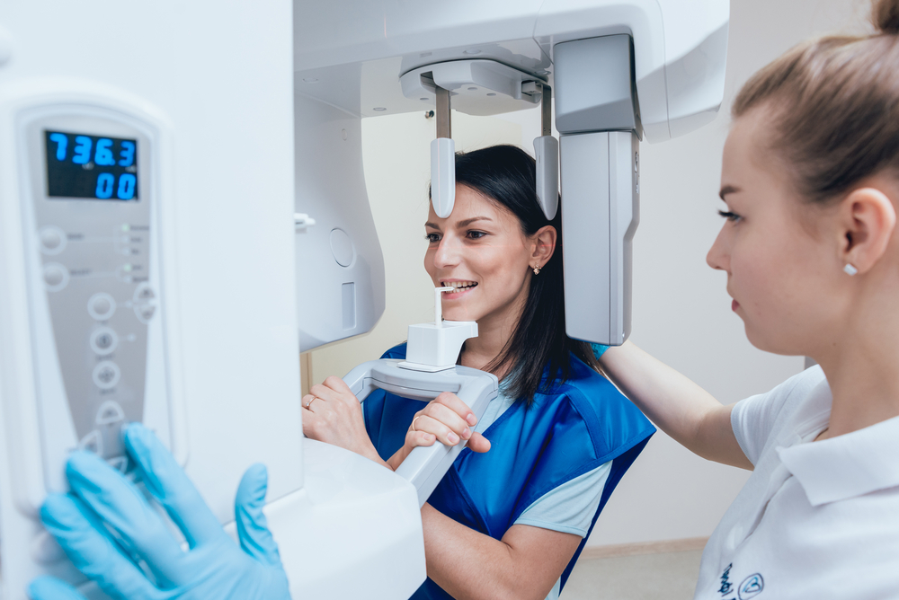 Young woman patient standing in x-ray machine.